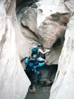 Leon and Patricia Barkman climbing a slot canyon in Utah